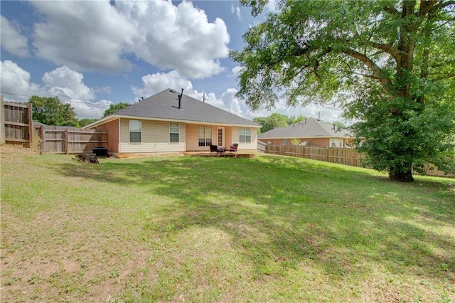 back of property featuring a fenced backyard and a yard