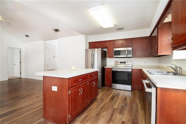 kitchen featuring visible vents, a sink, dark wood finished floors, and stainless steel appliances