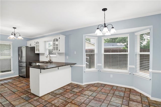 3011 Olde Gate Rd, Mobile, AL 36695 - kitchen featuring a chandelier, freestanding refrigerator, a peninsula, stone finish floors, and crown molding