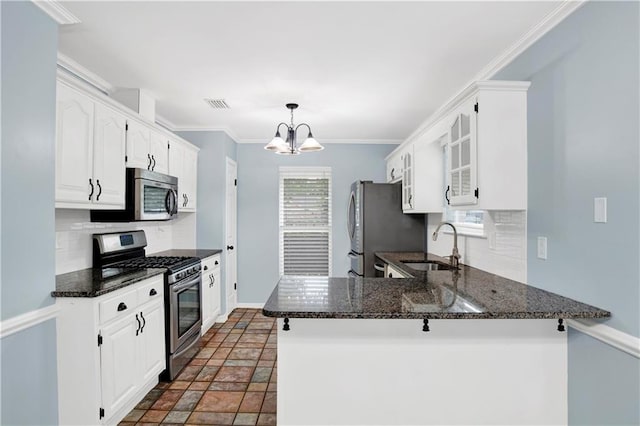 3011 Olde Gate Rd, Mobile, AL 36695 - kitchen featuring appliances with stainless steel finishes, decorative backsplash, a peninsula, white cabinets, and crown molding