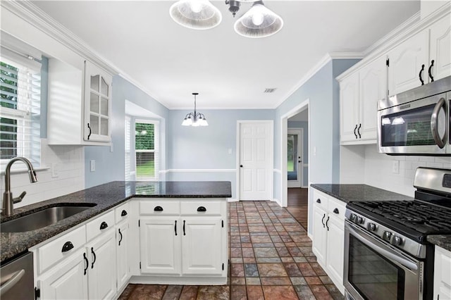 3011 Olde Gate Rd, Mobile, AL 36695 - kitchen featuring appliances with stainless steel finishes, white cabinets, tasteful backsplash, dark stone finish flooring, and ornamental molding