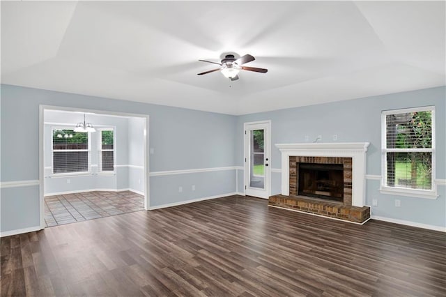 3011 Olde Gate Rd, Mobile, AL 36695 - unfurnished living room featuring dark wood-style floors, ceiling fan, a chandelier, a brick fireplace, and a raised ceiling