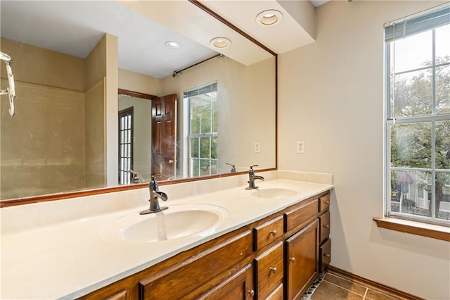 bathroom featuring tile patterned flooring, a sink, recessed lighting, and double vanity