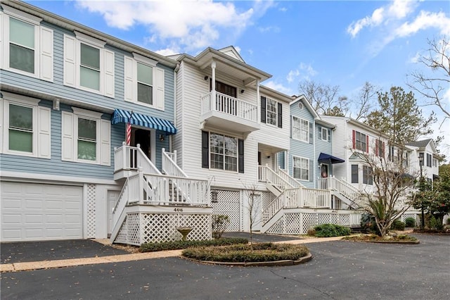 view of property featuring aphalt driveway, an attached garage, and a residential view