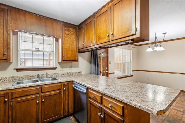 kitchen featuring a peninsula, a sink, light countertops, stainless steel dishwasher, and brown cabinets