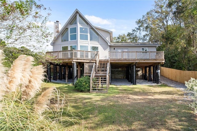 rear view of property featuring a lawn and a wooden deck