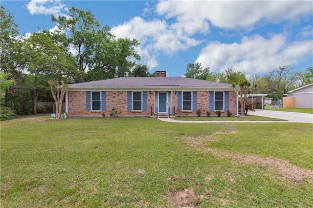 single story home featuring brick siding, a front yard, concrete driveway, and a chimney