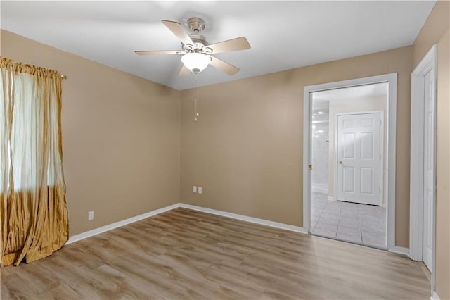 empty room with light wood-style floors, baseboards, and a ceiling fan
