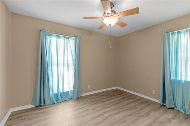 spare room featuring light wood-style flooring, ceiling fan, and baseboards