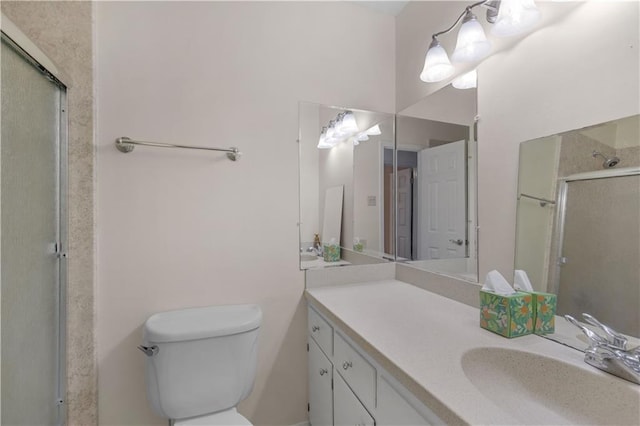 full bathroom featuring vanity, an enclosed shower, and toilet