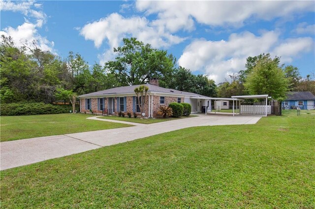single story home featuring a chimney, driveway, a front lawn, and brick siding