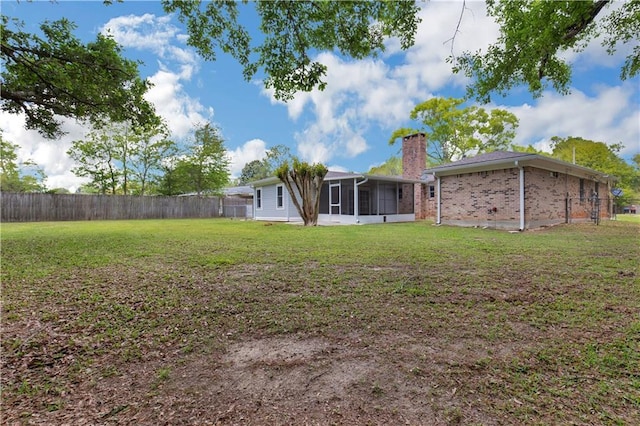 view of yard with fence and a sunroom