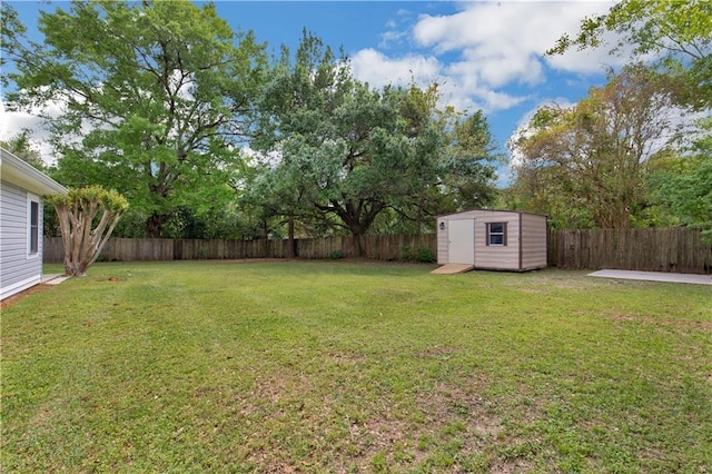 view of yard featuring a storage shed, an outbuilding, and a fenced backyard