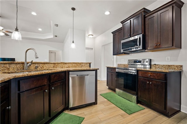 kitchen with stainless steel appliances, a sink, visible vents, light wood-style flooring, and dark brown cabinets
