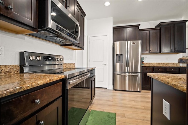 kitchen with recessed lighting, stainless steel appliances, light wood-style floors, light stone countertops, and dark brown cabinetry