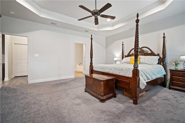 carpeted bedroom with crown molding, baseboards, a raised ceiling, connected bathroom, and visible vents