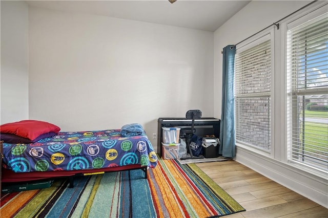 bedroom with baseboards and wood finished floors