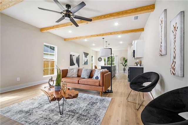 living room with light wood-type flooring, beam ceiling, and ceiling fan