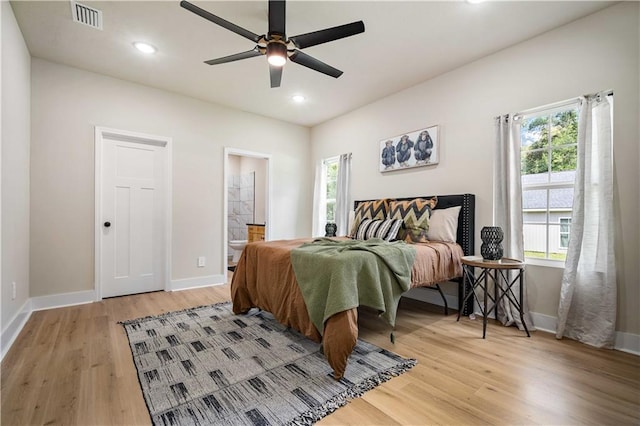 bedroom with ensuite bath, ceiling fan, and hardwood / wood-style flooring