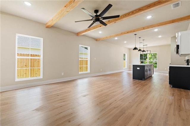 unfurnished living room featuring ceiling fan, light hardwood / wood-style flooring, and beamed ceiling