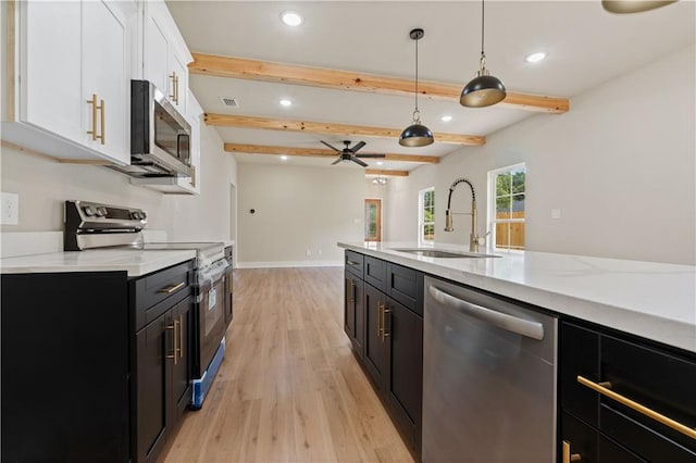 kitchen featuring stainless steel appliances, hanging light fixtures, ceiling fan, beam ceiling, and white cabinetry