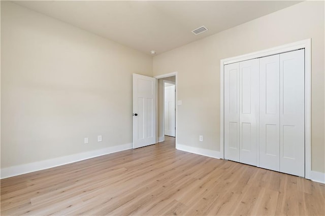 unfurnished bedroom with light hardwood / wood-style floors and a closet