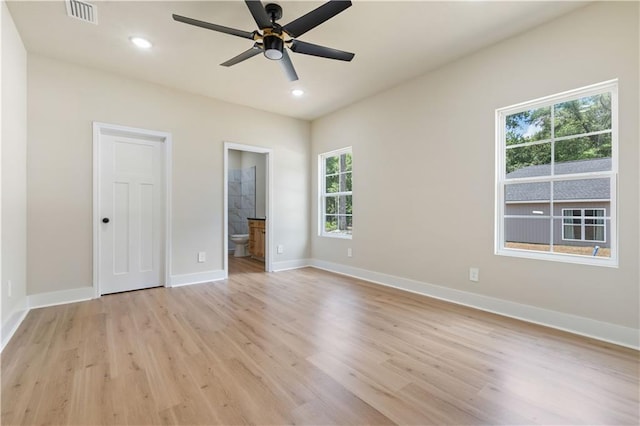 unfurnished bedroom featuring ensuite bath, ceiling fan, and light hardwood / wood-style flooring