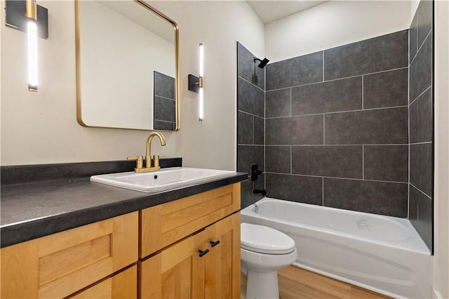 full bathroom featuring toilet, vanity, tiled shower / bath combo, and hardwood / wood-style flooring