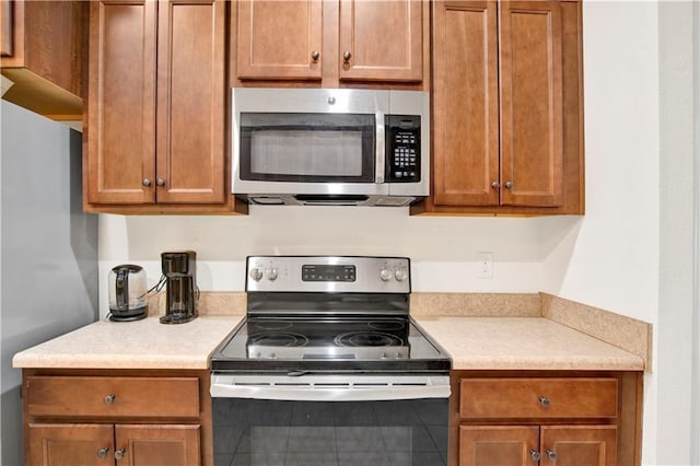 1468 Surrey Loop, Foley, AL 36535 - kitchen featuring stainless steel appliances, light countertops, and brown cabinetry