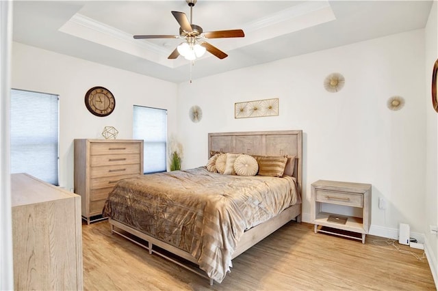 1468 Surrey Loop, Foley, AL 36535 - bedroom featuring a raised ceiling, light wood finished floors, crown molding, a ceiling fan, and baseboards