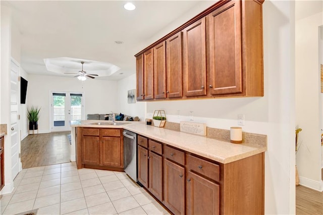 1468 Surrey Loop, Foley, AL 36535 - kitchen featuring dishwasher, a sink, a peninsula, a raised ceiling, and light countertops