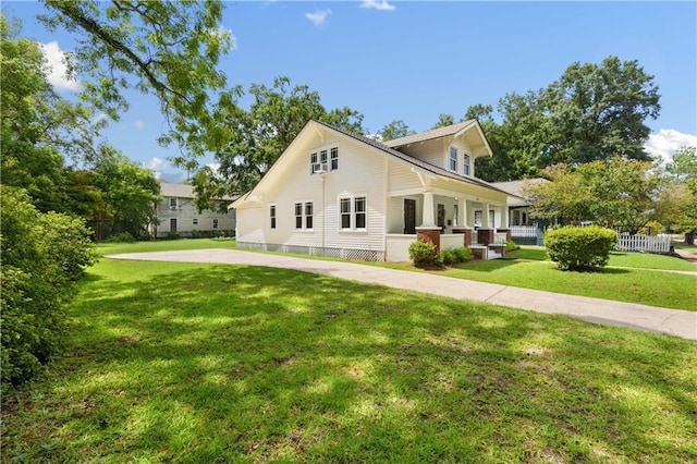 view of side of home with a yard and covered porch