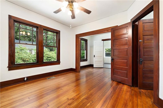 empty room featuring dark hardwood / wood-style flooring and ceiling fan