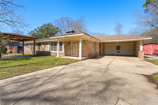 ranch-style house with a front yard, concrete driveway, brick siding, and an attached carport