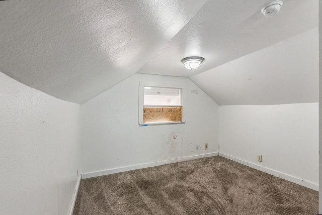 bonus room featuring baseboards, lofted ceiling, carpet flooring, and a textured ceiling