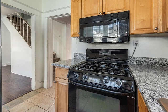 kitchen with black appliances and light tile patterned floors