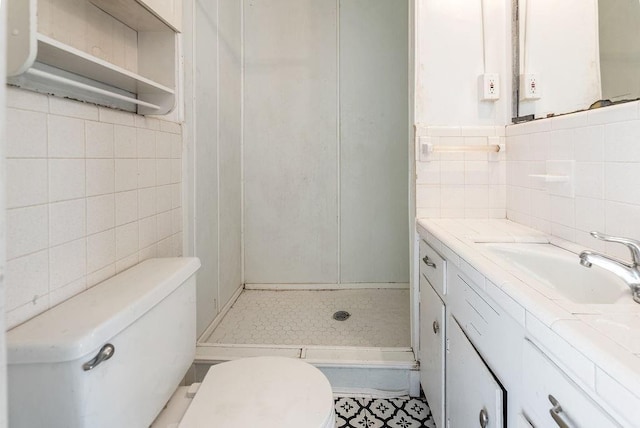 bathroom featuring tile walls, vanity, toilet, and a shower stall