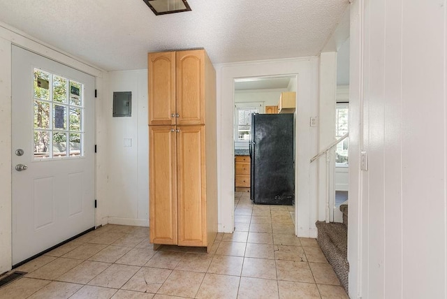 foyer featuring a textured ceiling, visible vents, electric panel, and light tile patterned floors