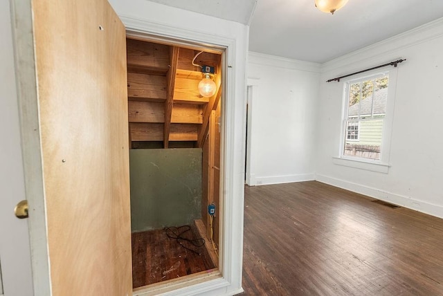 interior space with visible vents, ornamental molding, baseboards, and wood finished floors