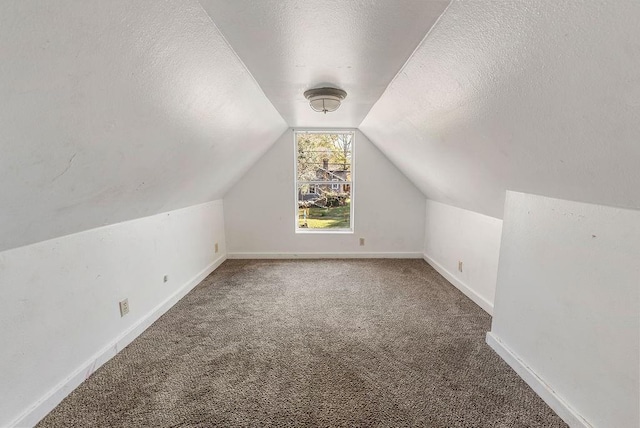 bonus room featuring baseboards, lofted ceiling, carpet floors, and a textured ceiling