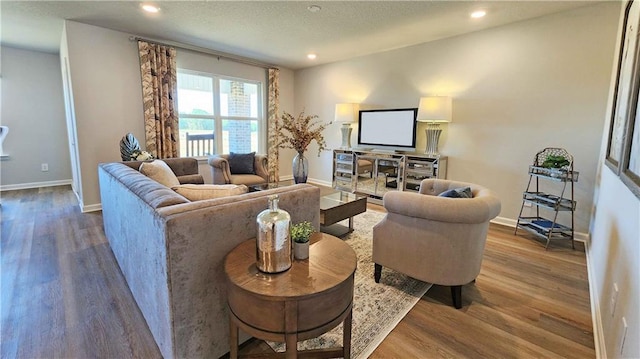 living area with recessed lighting, baseboards, and wood finished floors