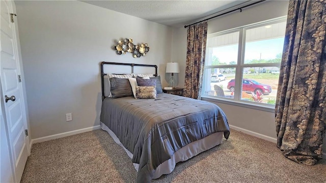 bedroom featuring carpet, baseboards, and a textured ceiling