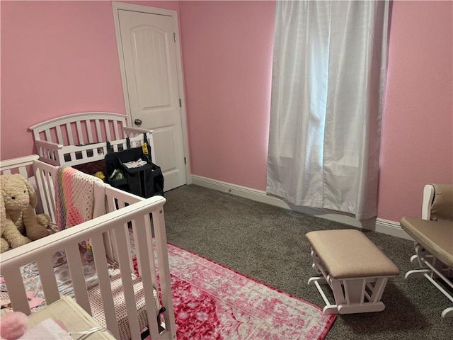 bedroom featuring carpet, baseboards, and a nursery area