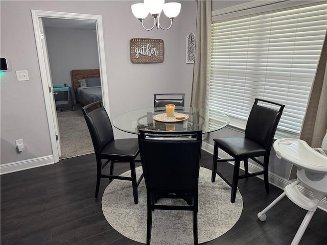 dining area featuring a chandelier, baseboards, and dark wood-style floors