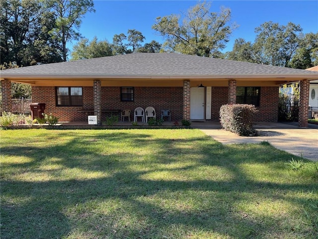 view of front of house with roof with shingles, a front lawn, and brick siding