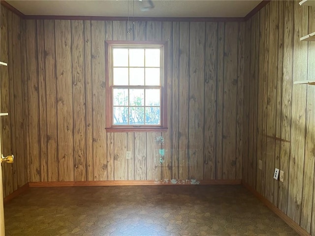 spare room with wood walls, baseboards, and tile patterned floors