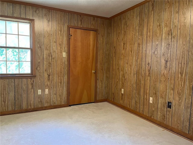 spare room featuring wood walls and baseboards