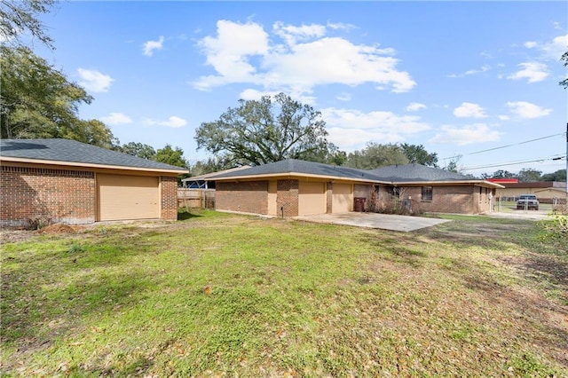 rear view of property featuring brick siding, a lawn, and a patio