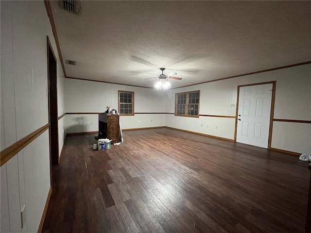 unfurnished living room featuring ceiling fan, ornamental molding, a textured ceiling, and dark hardwood / wood-style flooring