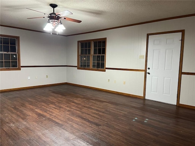 spare room with a textured ceiling, wood finished floors, a ceiling fan, baseboards, and ornamental molding